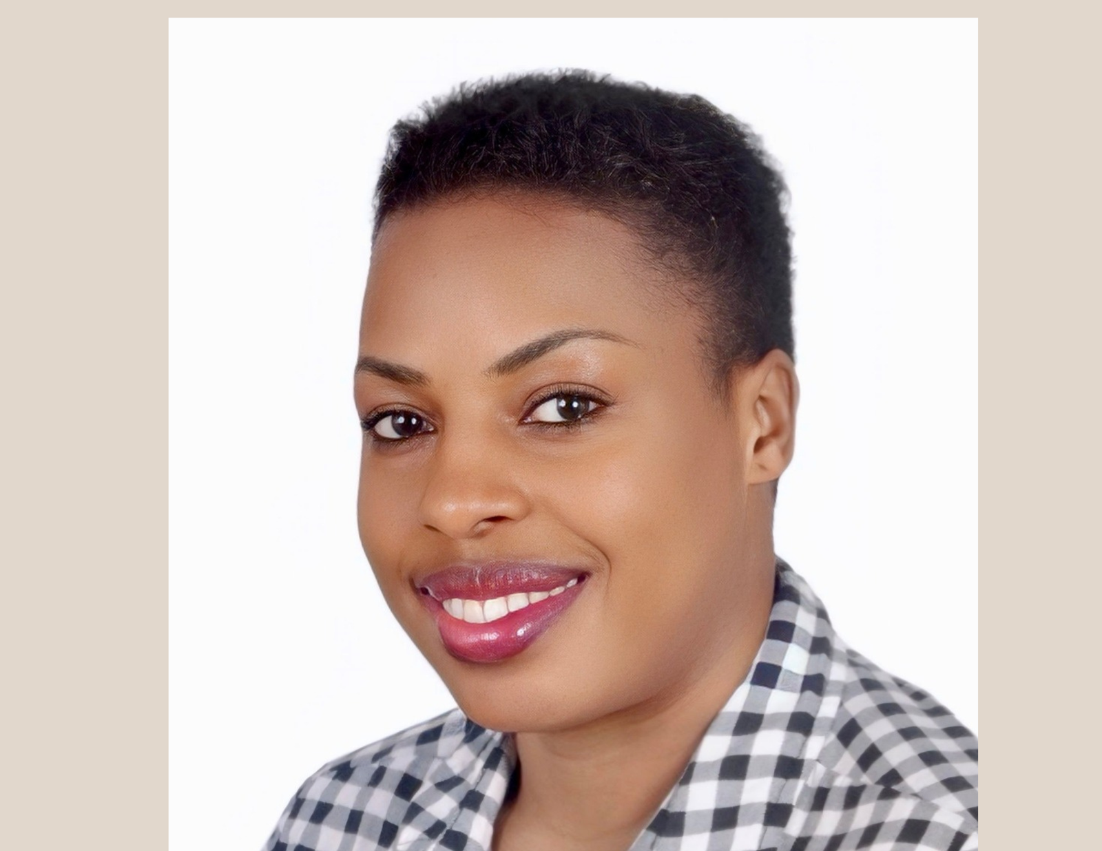 Annet Birungi Petch – Author Portrait Portrait of Annet Birungi Petch smiling, with short hair, wearing a square-patterned black and white blouse.